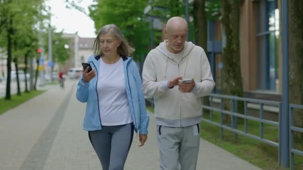Kıdemli Çift Eğitimden Sonra Yürüyorlar Telefonlarını Kullanıyorlar Olgun Adam Karısına — Stok video