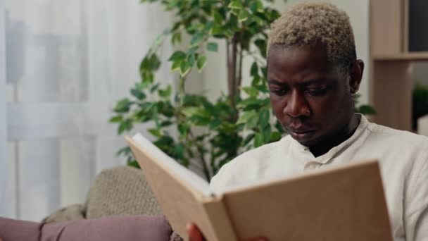 Vista Perto Homem Afro Americano Lendo Livro Depois Trabalho Sentado — Vídeo de Stock