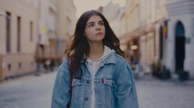 Beyaz kadın elinde bir çantayla caddenin ortasına gidiyor. Elinde gökkuşağı bayrağına boyanmış bir çanta var ve etrafa bakıyor. Halk konsepti