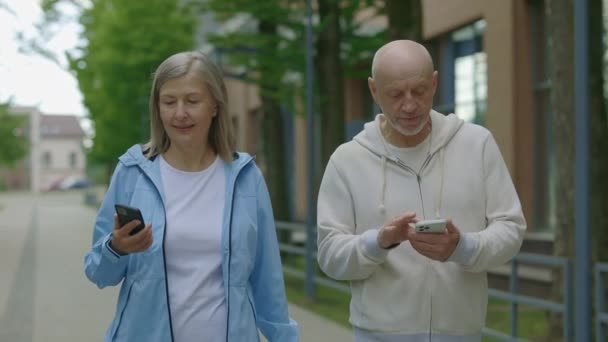 Dojrzała Para Chodzi Treningu Korzysta Smartfonów Starszy Mężczyzna Pokazuje Coś — Wideo stockowe