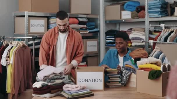 Disabled Multiracial Man Working His Caucasian Colleague While Sorting Clothes — Stock Video
