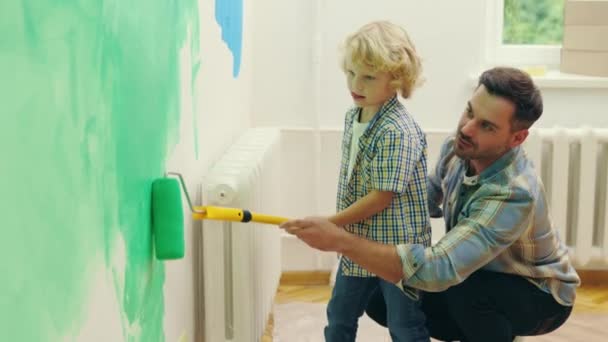Отец Сын Рисуют Стену Своем Доме Роликом Счастливый Мальчик Помогает — стоковое видео