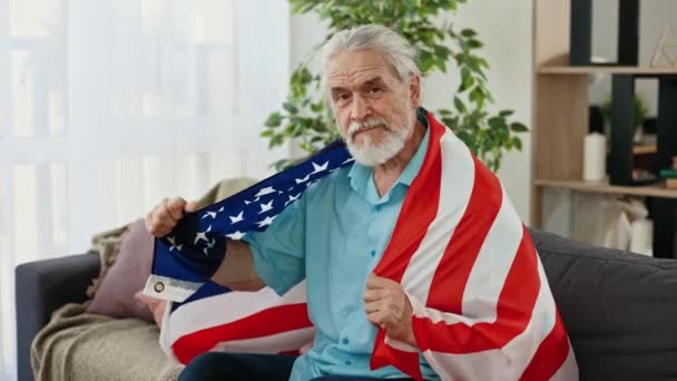 Homem Patriota Sênior Com Bandeira Americana Sentado Casa Olhando Para — Vídeo de Stock
