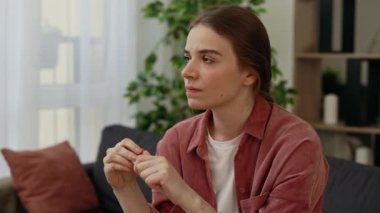 Hamilelik testinin sonucunu bekleyen korkunç, üzgün, beyaz kadın yakından görülüyor ve olumlu sonuç alınıyor. Çaresiz, mutsuz, depresyonda, pişman hissediyorum. Kanepede yalnız otur.