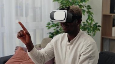 Afro-Amerikalı adamın yakından görüşü evde araştırma amaçlı kulaklık takması. Zevkli Afrikalı Amerikalı adam okumak için kafaya monte edilmiş ekranı kullanır