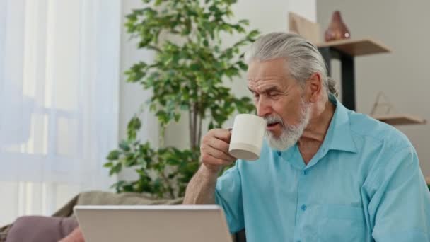 Ώριμος Καυκάσιος Άντρας Που Πίνει Ζεστό Καφέ Ενώ Δουλεύει Λάπτοπ — Αρχείο Βίντεο