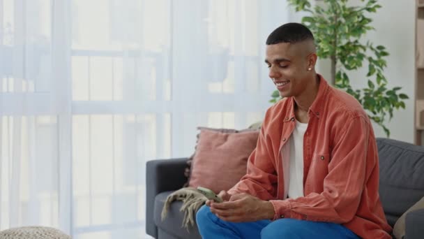 Happy African American Man Sitting Sofa Home Using Smartphone Attractive — Vídeo de Stock