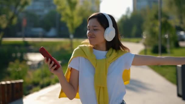 Glad Asiatisk Kvinna Lyssnar Musik Från Hörlurarna Håller Smartphone Dansar — Stockvideo