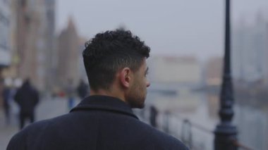 Şehir merkezindeki cadde boyunca yürüyen genç işadamlarının arka planı şehir merkezindeki şehir ışıklarına bakıyor. Ağır çekim. Halk konsepti