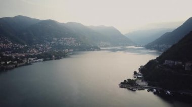 Drone shot of lake Como water in Alps of Italy. Aerial view of the lake and the mountains of the Como area. Sunrise