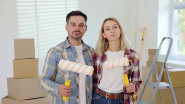 Portrait Couple Buying New Apartment Showing Paint Roller Caucasian Family — Vídeo de stock