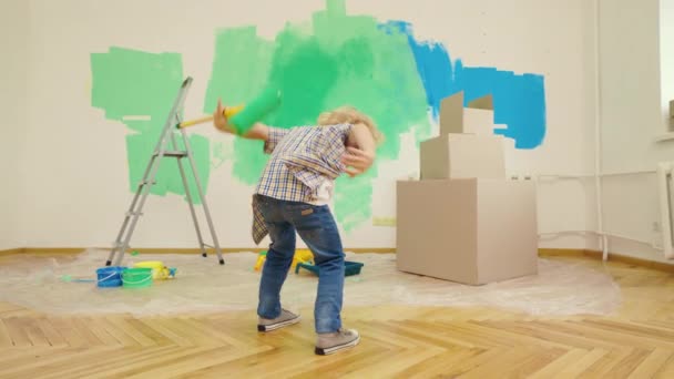 Menino Caucasiano Brinca Com Rolo Tinta Depois Pintar Parede Miúdo — Vídeo de Stock