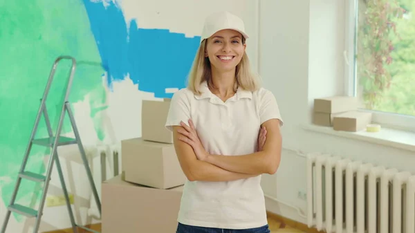 Taşıma şirketinde çalışan beyaz kadın işçinin portresi ya da ev yenileme şirketi. Özel üniformalı bir kadın, işten önce yeni bir dairede. Duvar boyama ve insanların konsepti.