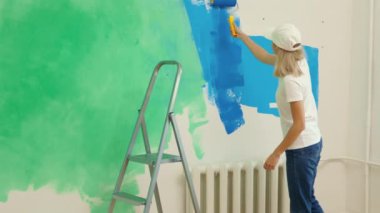 Tamir şirketinde çalışan kadın duvarları boyuyor. Yeni apartman dairesinde özel üniforma giyen, mavi renkli duvar boyayan bir kadın. İnsanlar ve resim kavramı