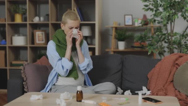 怀孕的不健康女人坐在客厅的沙发上 鼻子在组织里打喷嚏 未来生病的妈妈对家里的鼻塞和感冒症状感到厌倦 — 图库视频影像