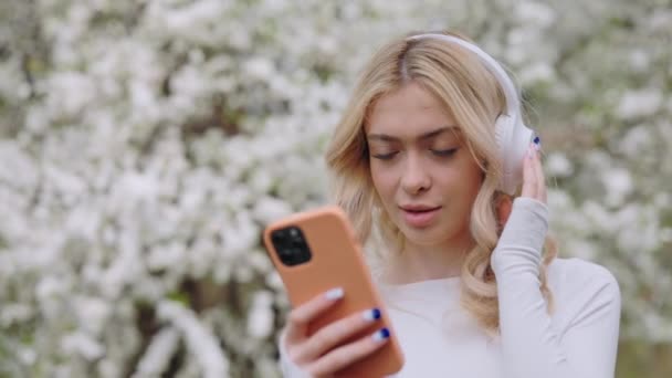 Красивая Молодая Блондинка Прокрутка Плейлист Современном Смартфоне Выборе Любимой Песни — стоковое видео