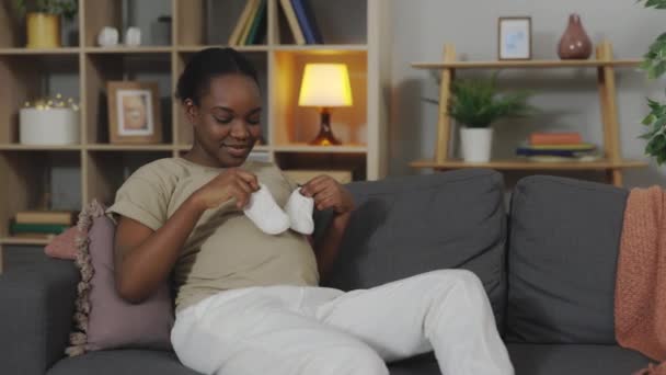 Young Pregnant African American Woman Playing White Baby Boots Her — Stockvideo
