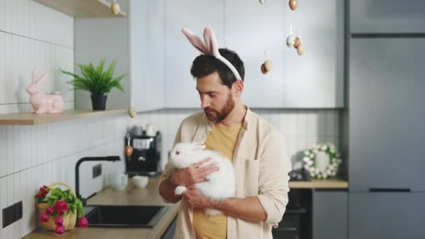 Portrait Smiling Handsome Man Holding Fluffy Easter Rabbit Wearing Bunny — Stockvideo