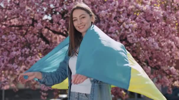 Attractive Patriot Woman Ukrainian Flag Hands Standing Background Sakura Blossoming — Stockvideo