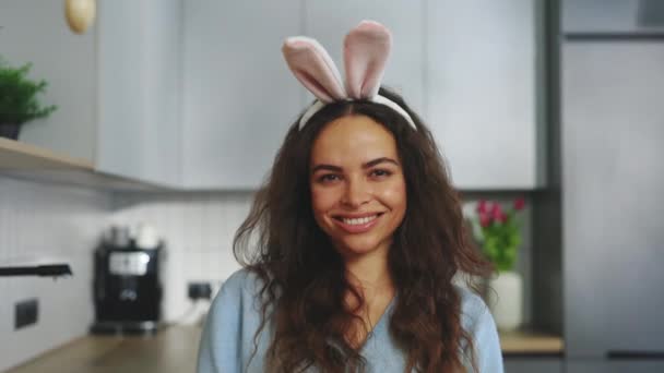 Portrait Smiling Woman Wearing Bunny Ears Headband Sitting Decorated Kitchen — Stock video