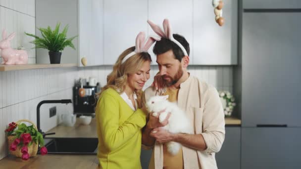 Portrait Happy Couple Holding Fluffy Easter Rabbit Wearing Bunny Ears — Vídeos de Stock