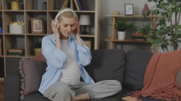 Güzel Hamile Bir Anne Kanepe Üzerinde Müzik Dinlerken Göbeğine Kablosuz — Stok video