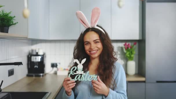 Portrait Smiling Woman Wearing Bunny Ears Headband Holding Easter Sign — Stock video
