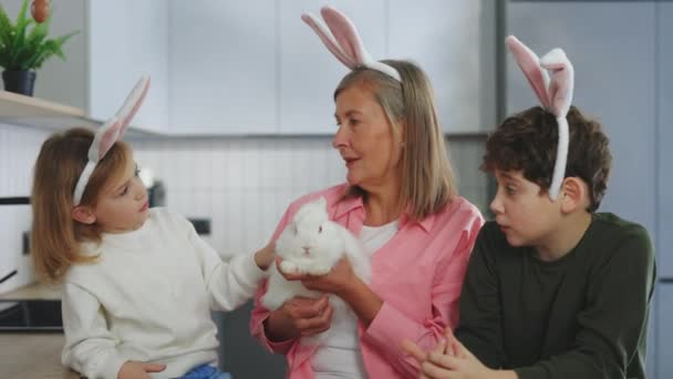 Happy Grandmother Holding Fluffy White Easter Rabbit Showing Him Her — Stockvideo