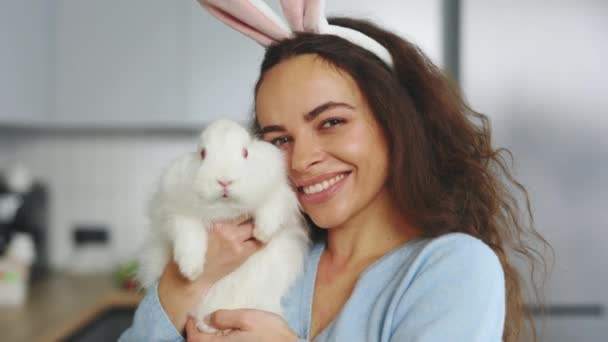 Portrait Smiling Woman Holding Fluffy Easter Rabbit Wearing Bunny Ears — Vídeo de stock