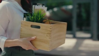 Business Woman Hold Box with Office Stuff from Her Table Leaving the Office Building Fired. Close Up View of the Hands Holding the Box with Containing Work Items