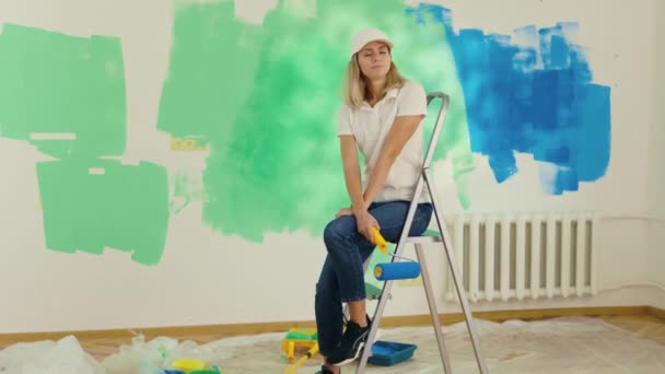 精疲力竭的女人在新家从墙上的画中休息 过度工作的概念 努力工作及维修服务 — 图库视频影像