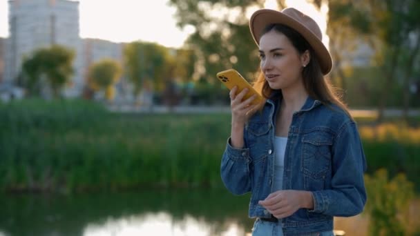 Beautiful Caucasian Woman Walking Park Wearing Hat Using Her Phone — Video Stock
