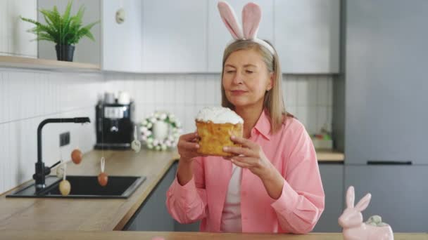 Старша Леді Кролячих Вухах Сидить Кухонним Столом Їсть Пасхальний Торт — стокове відео