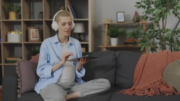 Ελκυστική Έγκυος Γυναίκα Στα Ακουστικά Ακούγοντας Μουσική Ενώ Κάθεται Στον — Αρχείο Βίντεο