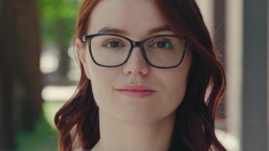 Portrait of the Beautiful Smiled Ginger Business Woman Wearing Formal Suit Standing near the Business Centre Looking at the Camera in Glasses. Close Up. People and Business Concept