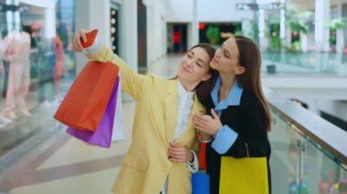 Happy Girls Taking Selfie Portrait on Smartphone Standing in the Modern Shopping Center. Young Attractive Women Taking Selfie after Shopping