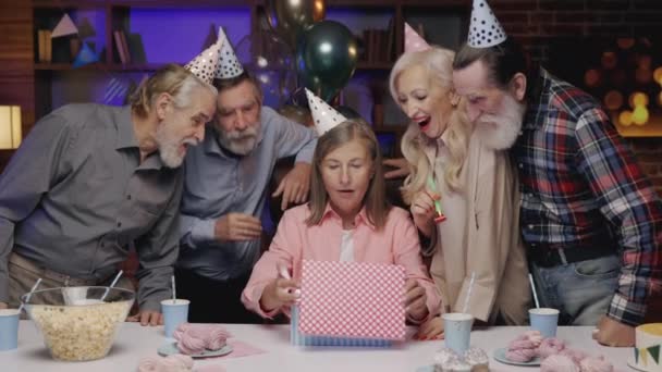 Entusiasmada Senhora Idosa Engraçada Chapéu Aniversário Abrindo Presente Celebrando Juntamente — Vídeo de Stock