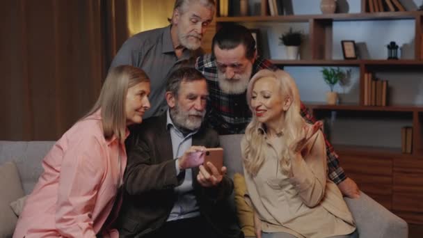 Gruppo Persone Mature Godere Utilizzando Smartphone Seduto Sul Divano Casa — Video Stock