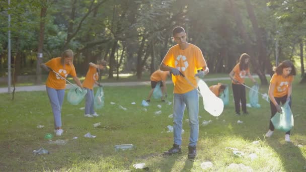 Többnemzetiségű Öko Aktivisták Csoportja Pólókban Újrahasznosító Szimbólum Tisztító Parkkal Emberek — Stock videók