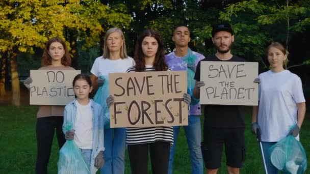 多民族生态志愿者团体肖像抗议垃圾托着纸板海报拯救我们的地球 没有塑料 拯救森林 垃圾回收利用 拯救生态 — 图库视频影像