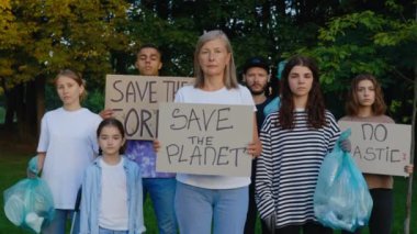 Parkta Çöp ve Posterler Gezegenimizi Kurtarıyor, Plastiksiz, Ormanı Kurtarıyor adlı çok ırklı Eko aktivisti Grubu. Dünya Çöp Kirliliğini protesto eden çeşitli gönüllüler. Çöpü Geri Döndür