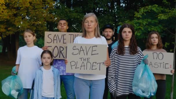 团体多种族生态活跃分子站在公园与垃圾和海报拯救我们的星球 没有塑料 拯救森林 不同的志愿者抗议地球垃圾污染 循环再造垃圾 — 图库视频影像