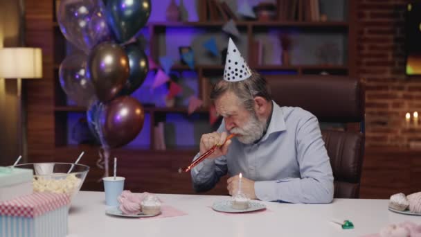 闷闷不乐的成年人坐在桌旁 低头看着烧着蜡烛的蛋糕 生日的时候感到很不快乐 孤独的人的概念 — 图库视频影像