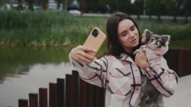 Güzel, gülümseyen beyaz kadın, sevimli küçük Chihuahua 'sıyla ve köpeğiyle selfie çekerek anılar yaratıyor. Teknoloji ve Köpekler İnsanlarla Dostluk Konsepti