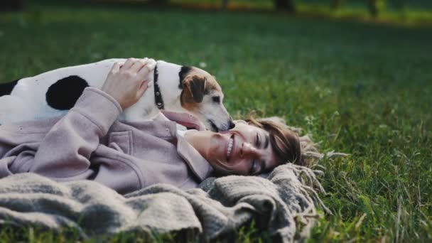 Pretty Woman Είναι Ξαπλωμένη Στην Κουβέρτα Στο Πάρκο Κρατώντας Σκύλο — Αρχείο Βίντεο