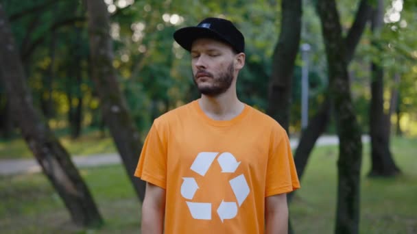 Üzerinde Geri Dönüşüm Sembolü Olan Kameraya Bakan Gönüllü Genç Adam — Stok video