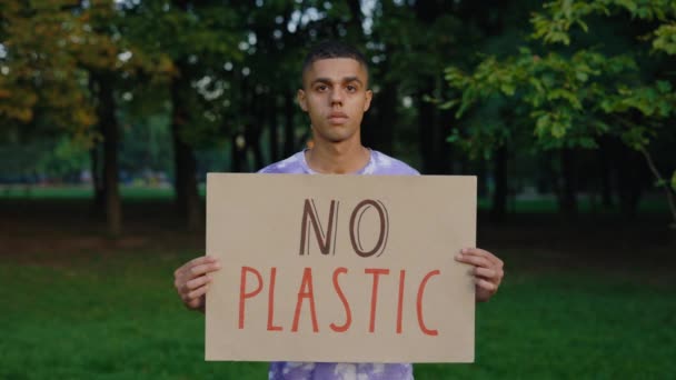 多民族男性活動家森の中で汚染に対する抗議の兆候を示すプラスチックポスターを保持していません 公開デモ エコ活動家 — ストック動画