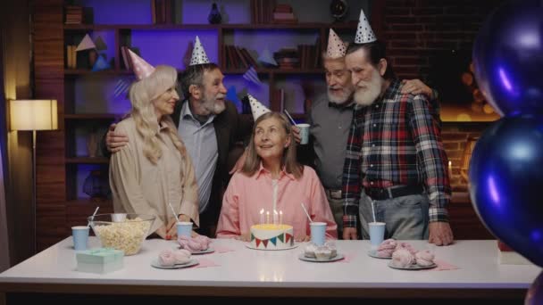 老年妇女生日聚会 老年组 老年女性吹蛋糕棒 积极对话 在养老院的生日朋友会上问候 身体包容 — 图库视频影像