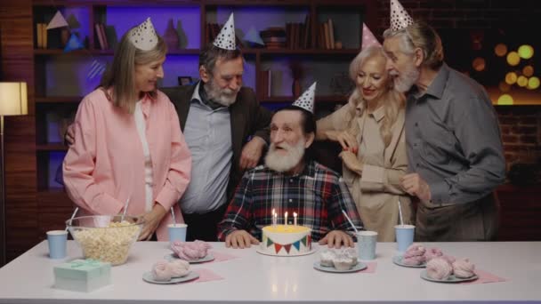 老年人的生日聚会 老年组 老年男性吹蛋糕烛台 在养老院的生日朋友会上问候 身体包容 主动退休 — 图库视频影像