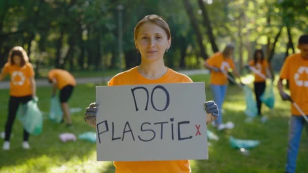无塑像生态海报女性活跃分子的肖像 妇女对森林中的污染表示抗议 收集垃圾的志愿者小组 公众示威 — 图库视频影像